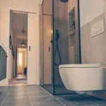 Salle de bain toilette avec WC suspendu et douche vitrée